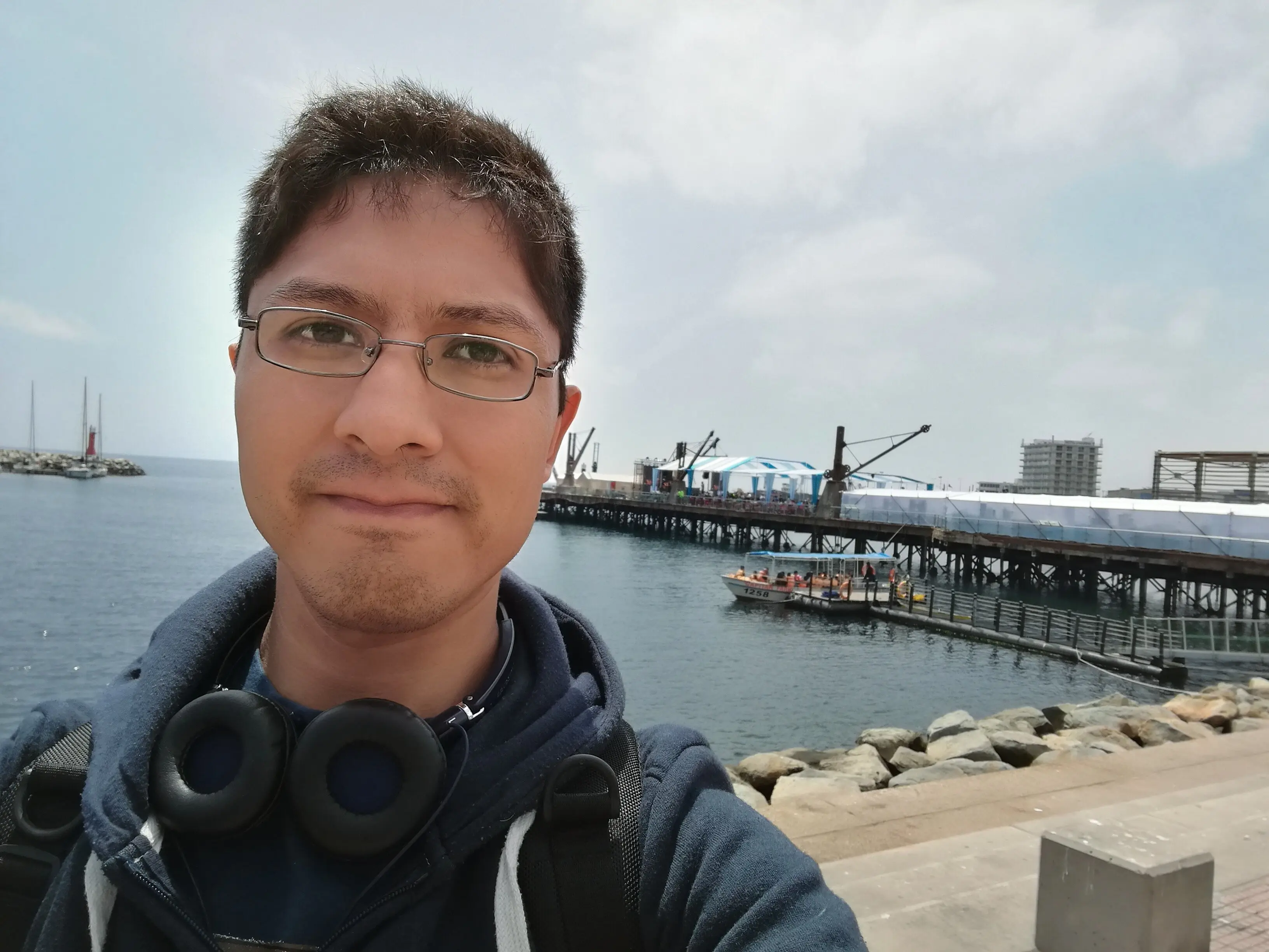 Porträt eines jungen Mannes am Flussufer mit Himmel im Hintergrund.